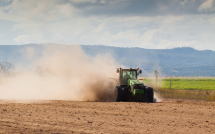 Tractor in field with excessive dust due to drought