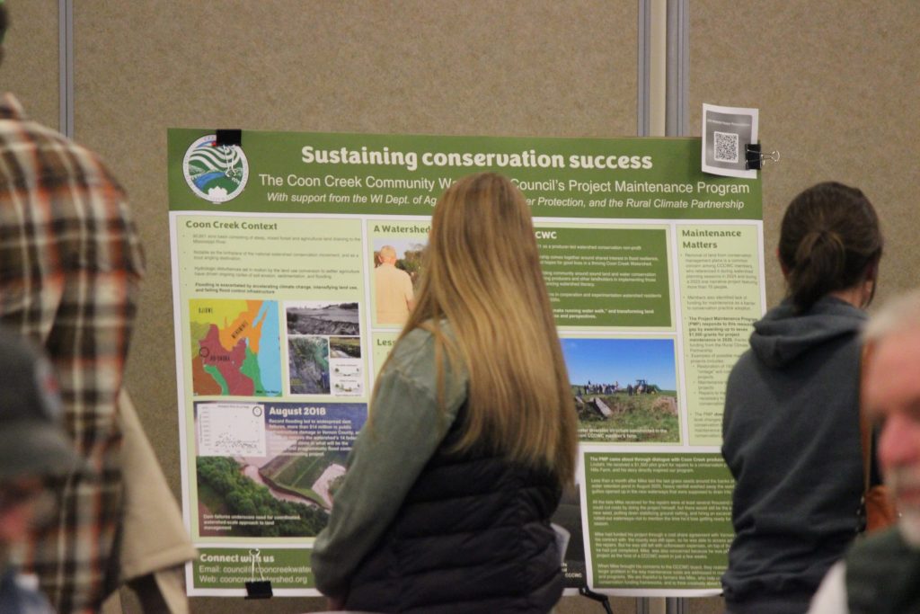 A person looks over an academic poster at a conference.